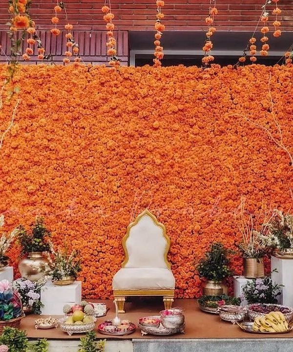 You can never go wrong with marigolds for a Haldi ceremony. I created this magnificent backdrop made entirely of bright orange marigolds, complemented by traditional brass pots and a classic white throne for the bride.