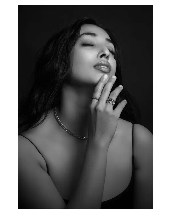 A black and white portrait that focuses on emotion and texture. The close-up on the model's face and the delicate jewelry creates a sense of intimacy and timeless beauty.