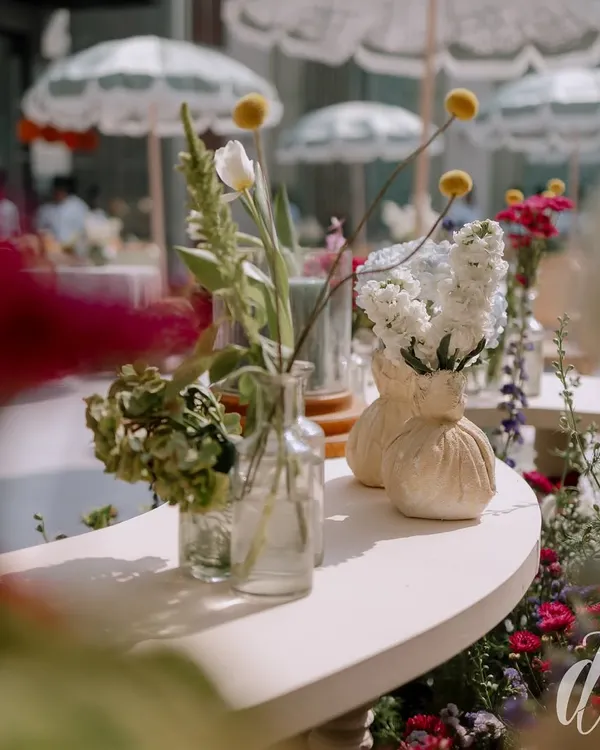 A close-up of the floral details from a spring luncheon. We used a mix of wildflowers in simple glass and ceramic vases, creating a look that is effortlessly chic and full of natural beauty.