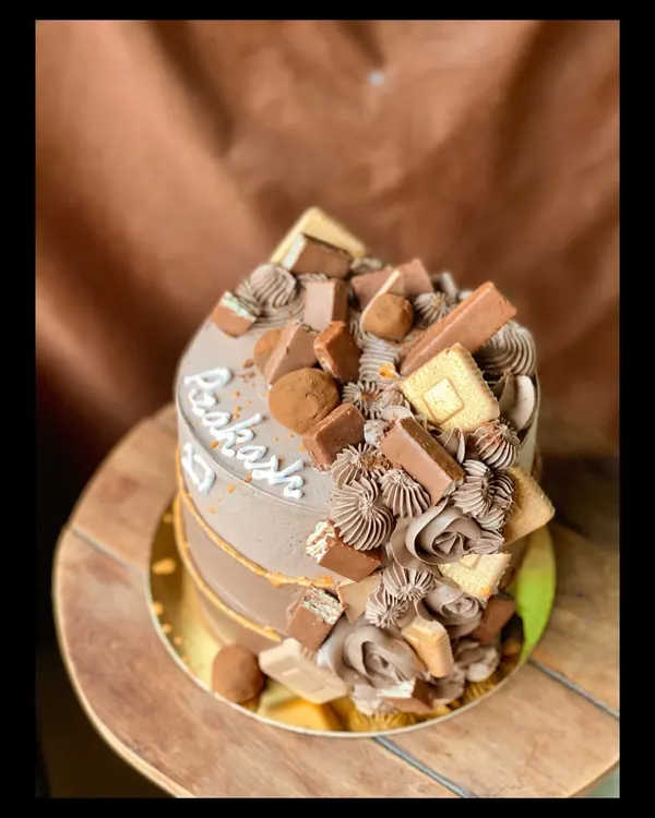 My Chocolate Overload cake is a dream come true for any chocolate lover. It's topped with a mountain of various chocolates like KitKat, Dairy Milk, and chocolate truffles.