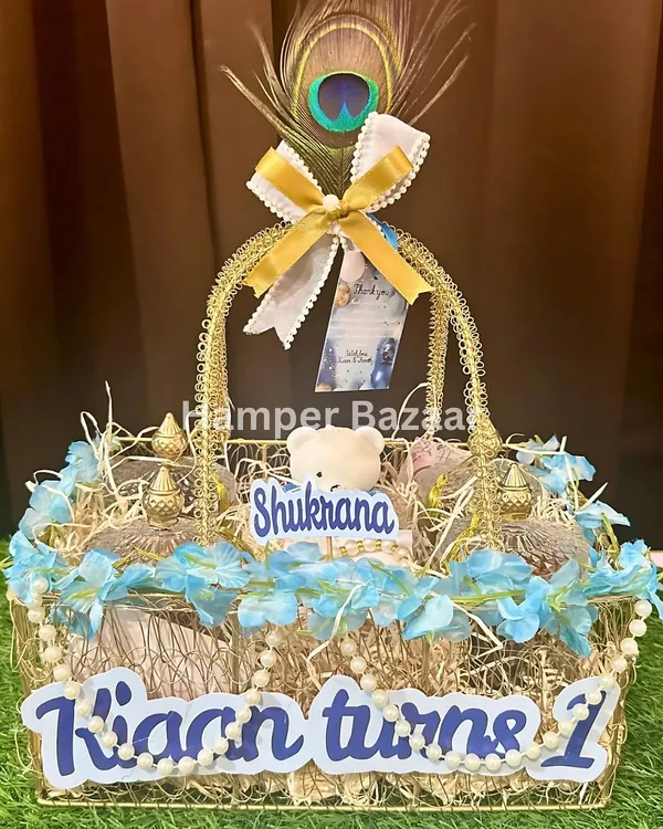 A close up of a personalized birthday return hamper for Kian's first birthday. We used a 'Shukrana' theme with peacock feathers to add a touch of grace and gratitude.