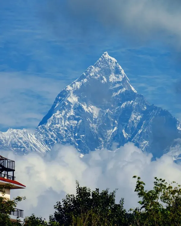 The majestic peak of Machapuchare, or Fishtail Mountain, piercing through the clouds. This is a view that greets our trekkers on the Annapurna Base Camp trail, a constant and inspiring companion.