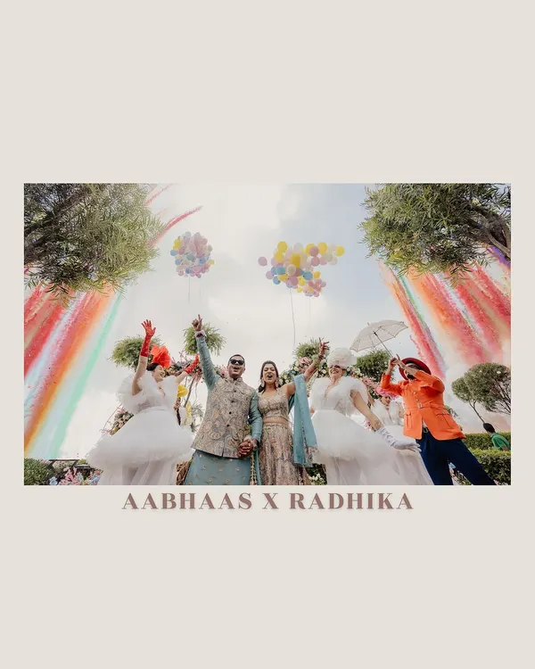 A Haldi ceremony that is bursting with color and joy. This shot captures the fun and playful spirit of the event, complete with rainbow decor and performers, creating a truly festive atmosphere.