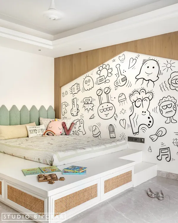 This kids' room at Noor Haus is a world of imagination. We designed a raised platform bed with integrated storage and a playful house-shaped cutout behind it, which we had hand-painted with whimsical doodles.