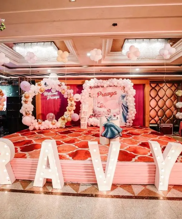 This was a welcome party fit for a princess. I designed a complete Cinderella world for baby Pravya, with a grand stage, custom light-up marquee letters spelling her name, and a beautiful balloon ring, all in a dreamy pastel color palette.