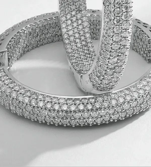 This macro photograph captures the intricate detail of pavé-set diamond hoop earrings. Every single diamond is in sharp focus, demonstrating the precision required for high-end e-commerce imagery where texture and quality are paramount.