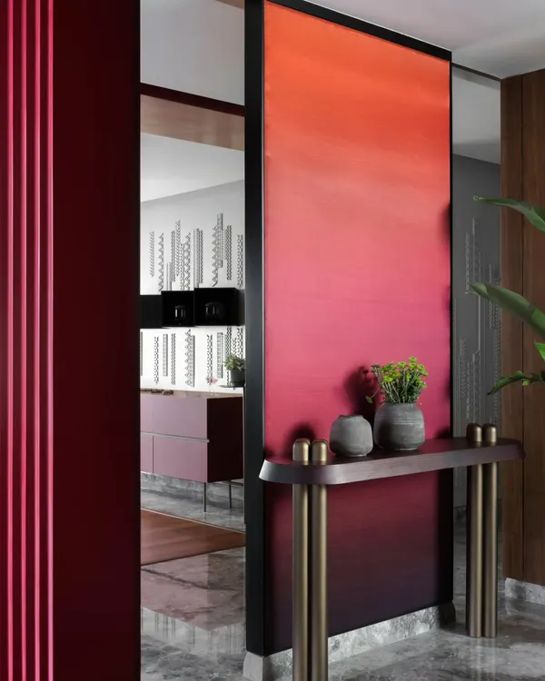 The entrance to the Scarlet Horizon living area is framed by a bold, ombré-painted partition, creating a powerful visual transition. This design choice was a daring departure from safer palettes, reflecting the unique and vibrant personality of the homeowners.