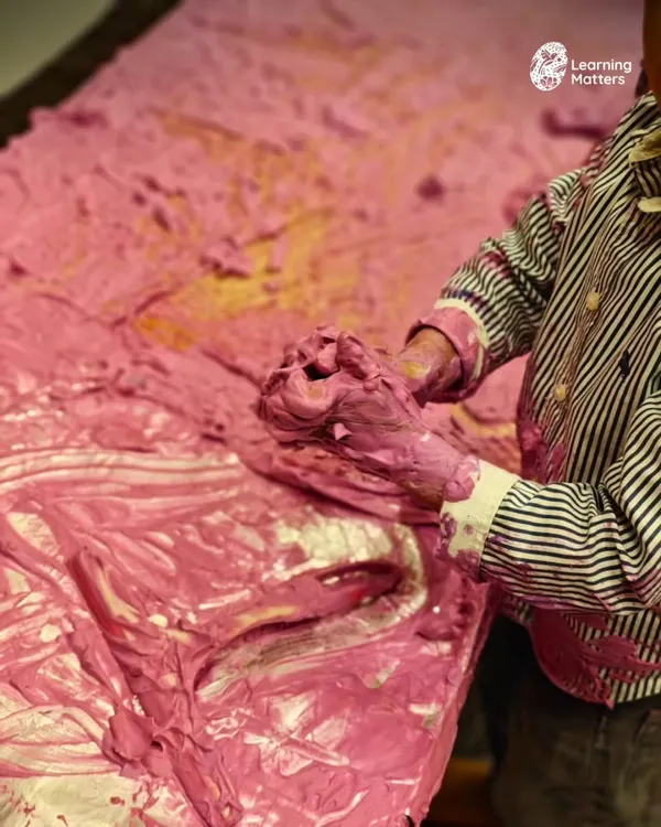 A child's hands deep in a mountain of pink foam is a full-body sensory experience. The unique texture and vibrant color invite exploration, supporting language development and emotional expression in a joyful, open-ended way.