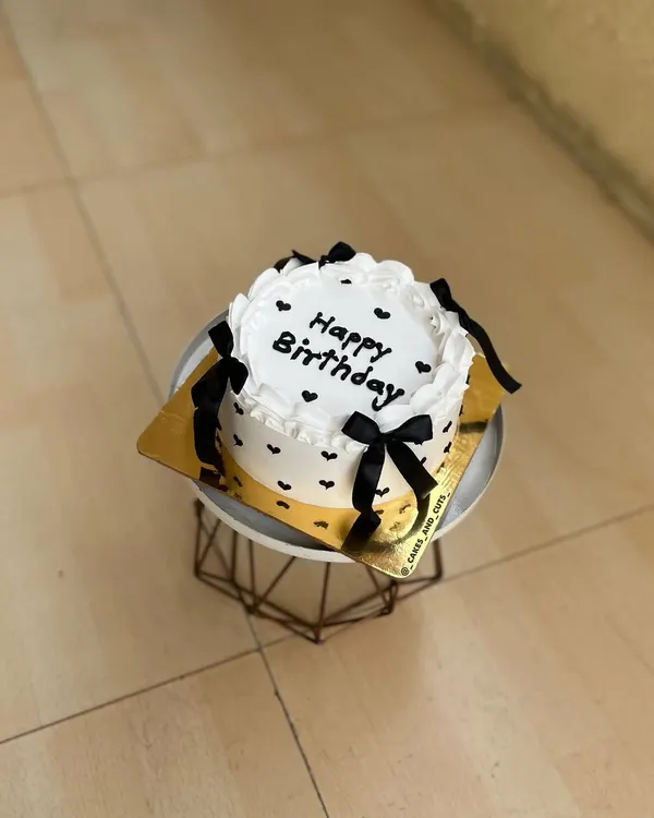 A cute and simple vintage-style bento cake with black bows and hearts, perfect for a small celebration.