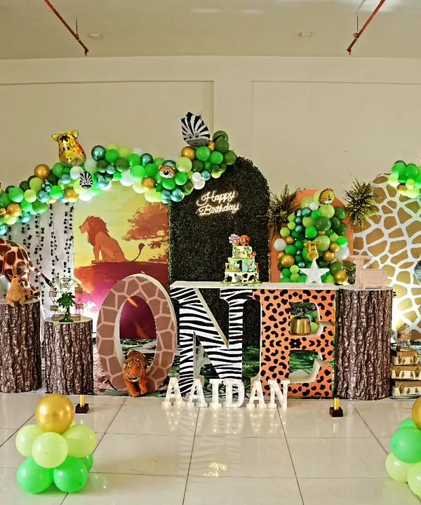Aaidan's first birthday was a walk on the wild side with this elaborate jungle theme. We used a life-sized giraffe prop, animal print "ONE" letters, a greenery backdrop, and a lush balloon arch to create a full safari experience.