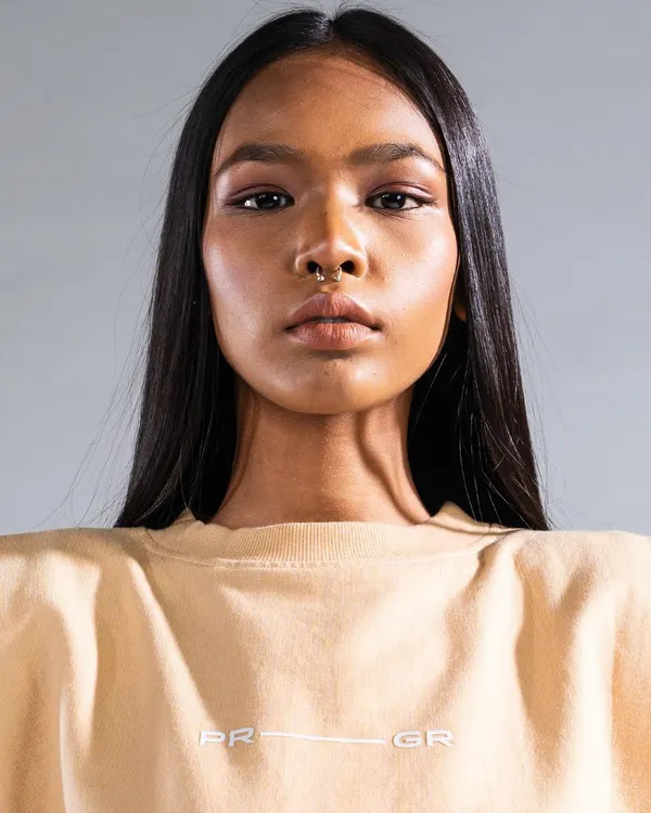 A close-up from a high-fashion campaign, focusing on flawless, glowing skin and clean, defined makeup. The look is complemented by sleek, straight hair, creating a modern and striking editorial image.