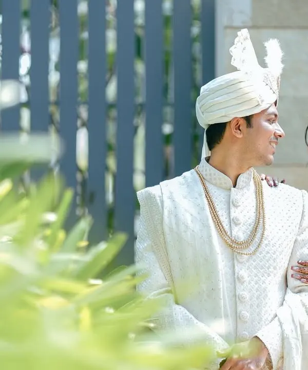 A classic, romantic portrait of a couple. The groom looks lovingly at his bride, who smiles back, her hand resting gently on his arm. A timeless capture.