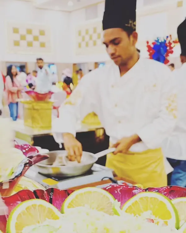 One of our chefs preparing fresh pasta at a live station. Guests can watch their meal being cooked, ensuring it's hot, fresh, and made just the way they like it.