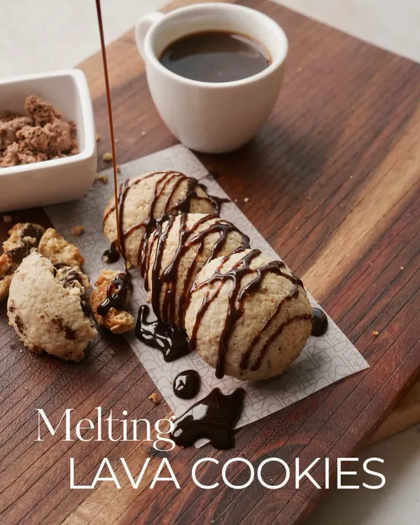 A close-up of my gluten-free Lava Cookies, with rich, dark chocolate being drizzled over them. This is pure, guilt-free indulgence, baked fresh just for you.