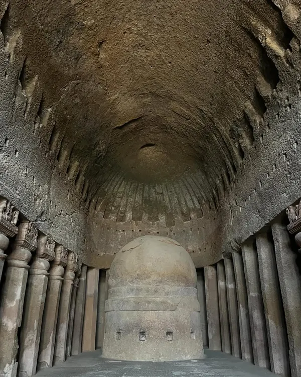 The main prayer hall at Kanheri Caves, showing the massive stone stupa under a chaitya arch, a marvel of ancient rock-cut architecture.