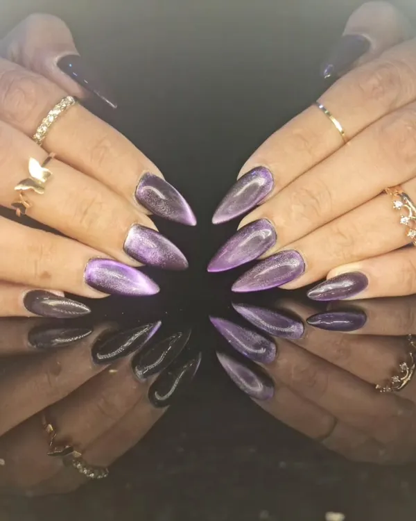 A stunning set of purple cat-eye nails on long stiletto extensions, showing a beautiful diagonal shimmer that moves with the light.
