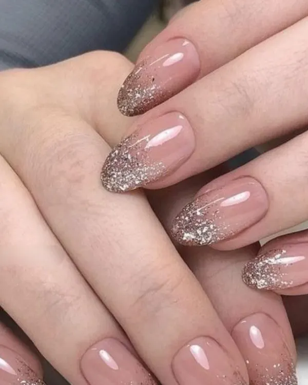 A beautiful and elegant design featuring a sheer nude base with a sparkling gold glitter gradient starting from the tips.