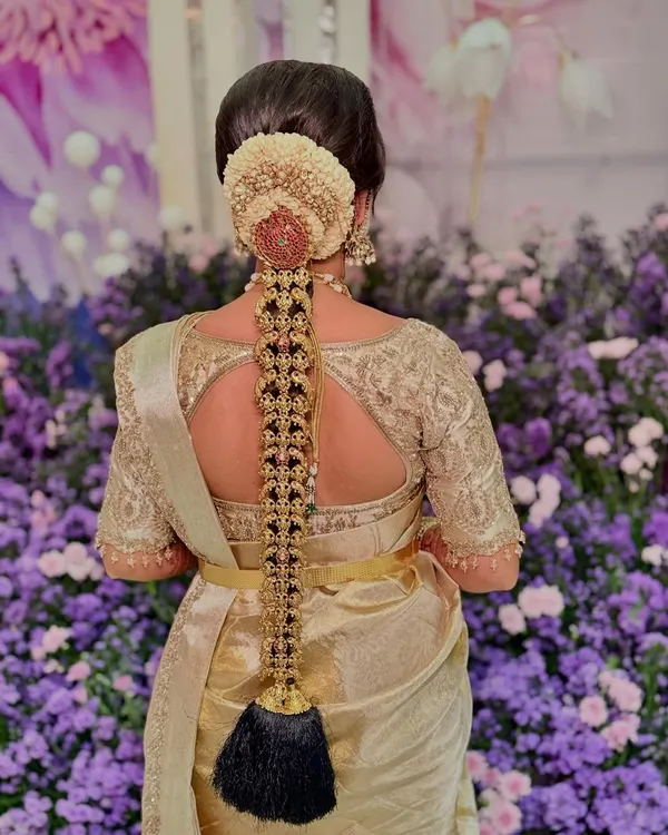 The breathtaking detail of a traditional South Indian bridal braid for Sushmitha, adorned with exquisite temple jewelry. This is wearable art.