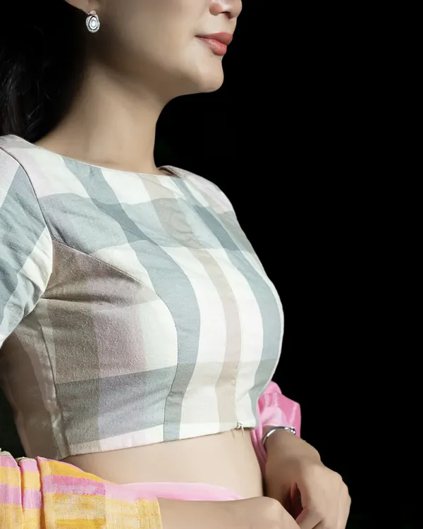 Elevate your ethnic wardrobe with this pure cotton blouse in a subtle check pattern. The boat neck and elbow-length sleeves offer a flattering silhouette, while the front zipper adds a modern, practical touch.