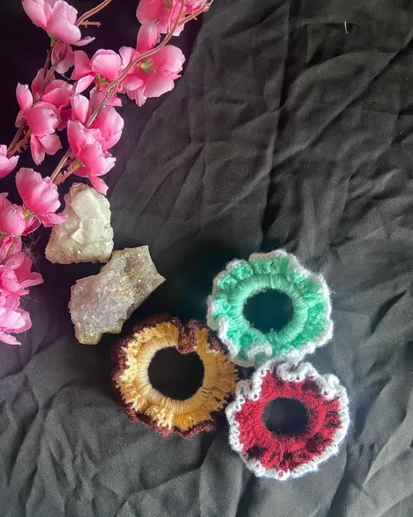 A collection of three custom scrunchies showing some color possibilities. Here you can see a mint green one, a red one with a white ruffled edge, and a yellow one with a brown edge.