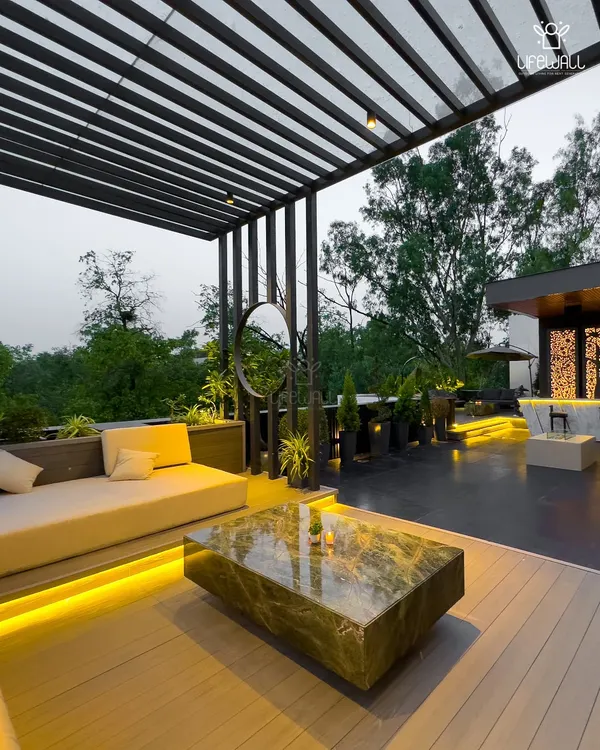 This modern, black metal pergola creates a sophisticated lounge area. The slatted roof offers partial shade, while the under-seat lighting adds a warm glow for evening gatherings.