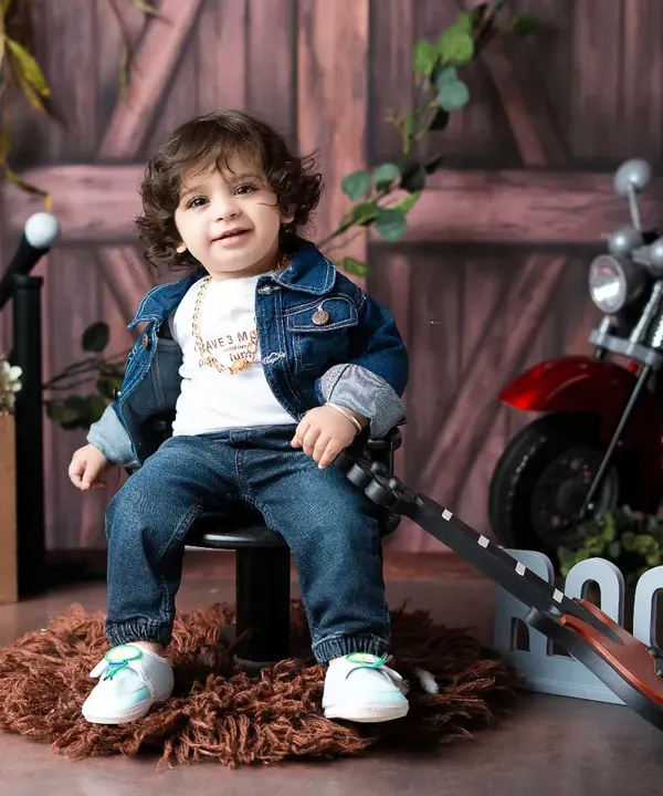 Our little rockstar takes a break from his world tour. This themed toddler photoshoot includes a full set with a guitar, disco ball, and motorcycle prop for a fun and dynamic session.