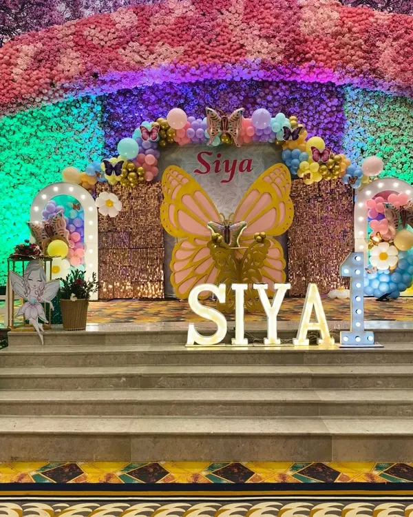 This grand butterfly-themed stage is perfect for a first birthday party. I designed this entire setup with a large sequin backdrop, a huge butterfly cutout, marquee letters for the name, and a colorful balloon arch to create a magical photo corner.