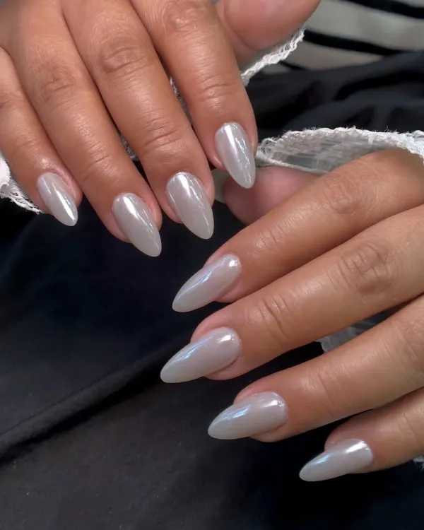 This is my popular pearly chrome finish. It gives the nails a beautiful, high-shine, iridescent look that is both trendy and timeless. It looks stunning on these long, almond-shaped nails.