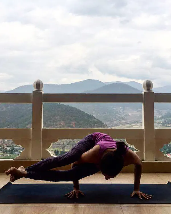 This is the feeling we chase on our retreats. Here, I am holding an Astavakrasana, or Eight-Angle Pose, on a balcony overlooking the vast mountains of Bhutan. An advanced arm balance like this requires focus and strength, and practicing it with the Himalayan air around you is a truly grounding experience.