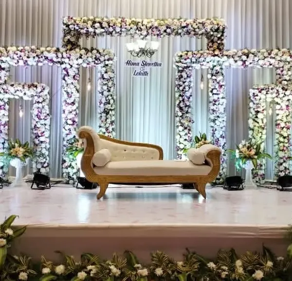 This elegant engagement stage features multiple floral frames and a classic chandelier, creating a grand and sophisticated backdrop. We design these multi-layered structures to add depth and luxury to your main event area.
