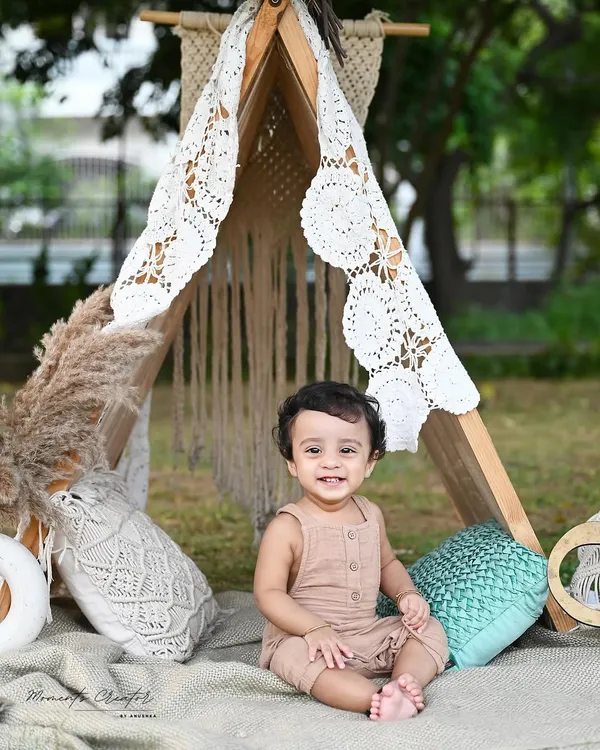 A happy little camper enjoying the outdoors. This boho-themed outdoor session with a lace teepee and natural textures is perfect for capturing a baby's adventurous spirit.