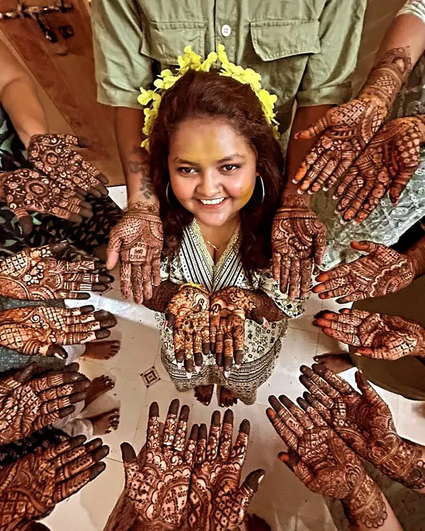 The quintessential mehendi ceremony photo. A radiant bride surrounded by her 'team bride', all showing off their beautiful henna. It's a moment of pure joy and togetherness.