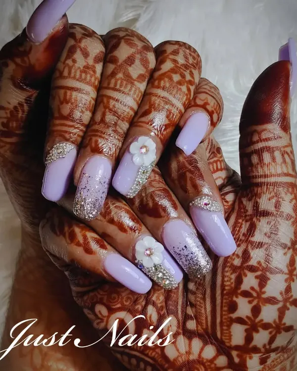 For the modern bride, this lavender nail extension set combines a solid pastel with sparkling glitter, 3D floral art, and delicate rhinestone placement. This design looks stunning against traditional Mehendi, creating a perfect balance of contemporary style and bridal tradition.