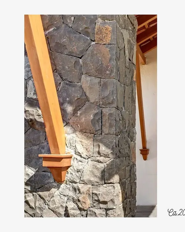 A detail of a stone column meeting a wooden support beam at the Lake Pawana Resort, built circa 2012. This junction highlights the honest expression of materials, where the texture of the local stone contrasts with the smooth finish of the timber.