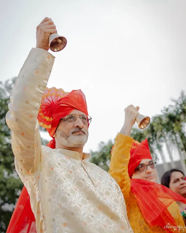 The fathers of the bride and groom ringing bells during the Maharashtrian wedding ceremony.