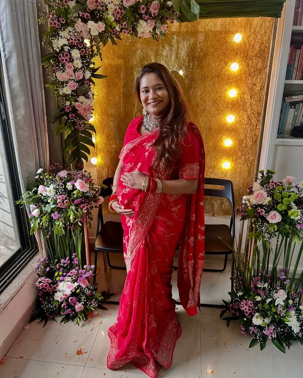 A moment from my own baby shower, feeling all the love and blessings. I chose a soft, radiant makeup look to go with my red saree, keeping it comfortable and glowing.