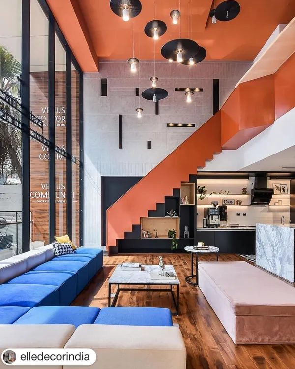 The heart of the Venus Communiti coworking space. The combination of a striking orange staircase, double-height ceilings, and a mix of comfortable lounge furniture creates an impressive and functional central hub for members.