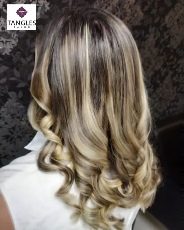 This is our hero item. A perfect example of a sun-kissed, golden blonde balayage. We achieved this look by hand-painting highlights to create a seamless, natural gradient, finished with soft curls to enhance the dimension and shine.