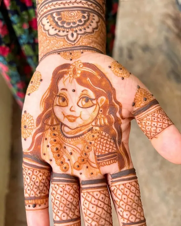 A close-up of a baby Radha portrait, a popular request for baby shower mehendi. The details in her jewelry and expressive eyes bring a divine blessing to the design.