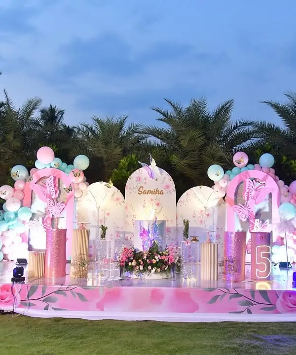 This is what I call a magical birthday. For this outdoor butterfly theme, I created a grand stage with custom panels, lush floral arrangements, and a sea of pink and mint balloons to bring a fairytale to life.