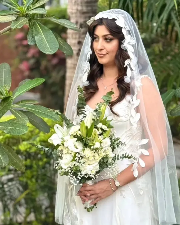 This bride was an absolute vision in her white gown. We opted for soft, romantic waves cascading under a delicate, leaf-patterned veil for a touch of ethereal beauty.