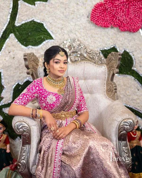 Our bride looking regal in her complete wedding ensemble. The heavily embroidered pink zardozi blouse perfectly complements her lavender and silver Benarasi silk saree, creating a picture-perfect moment.