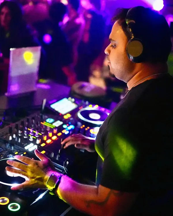 In the zone, with my hands on the decks under the vibrant club lights. This is my office, where I blend tracks and control the energy of the night.