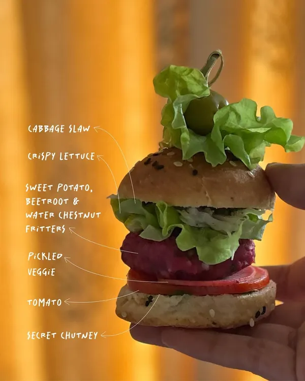 Here’s a closer look at what makes my mini sliders so special. It starts with a freshly baked bun, then a layer of my secret chutney, tomato, pickled veggies, a sweet potato and beetroot fritter, crispy lettuce, and cabbage slaw. Each layer adds a different texture and flavor.