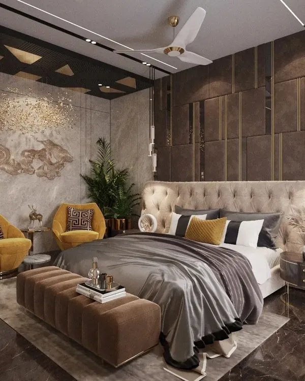 This master bedroom in Lucknow is a study in opulent design, featuring dark, textured wall panels with gold accents and a tufted wingback headboard. The mustard yellow armchairs add a rich, jewel-toned contrast to the moody and luxurious space.