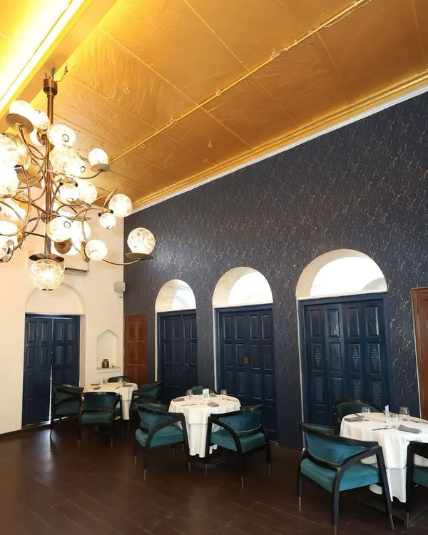 A wide view of our main indoor dining hall, where a stunning glass chandelier hangs from a gold leaf ceiling. This space is perfect for hosting larger groups for an elegant sit down dinner.