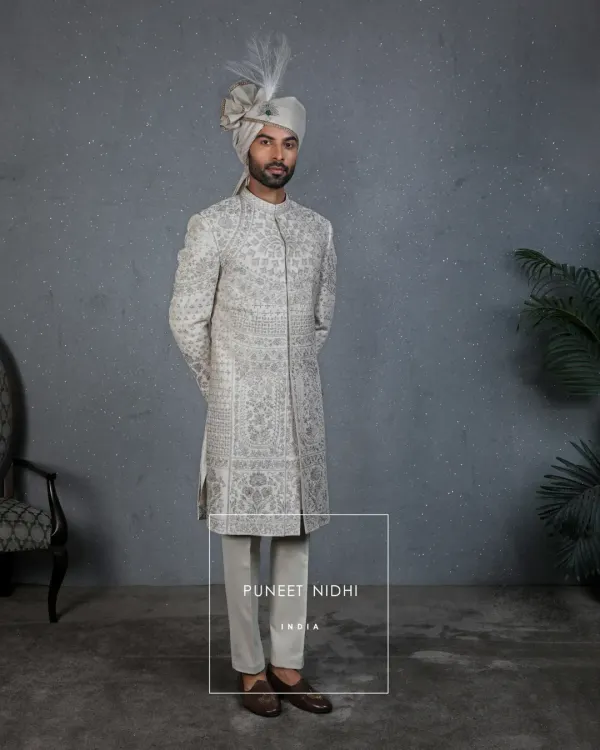 A full view of my handcrafted ivory sherwani, a reflection of India’s timeless grandeur. Paired with a feathered turban, it is designed for the groom who is ready to begin his new chapter with elegance and pride.