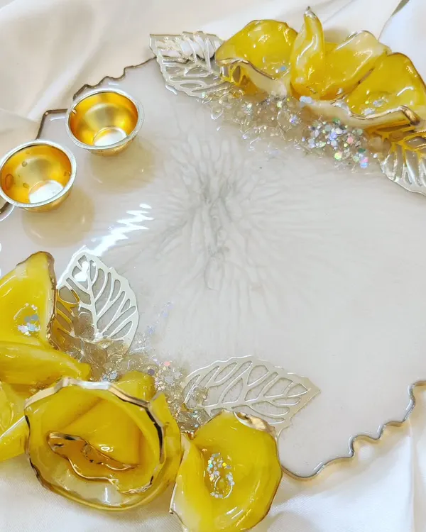 A beautiful handmade Rakhi platter or Puja Tilak Thali. This piece with 3D yellow flowers and silver leaves is perfect for Raksha Bandhan and Ganpati festivals.