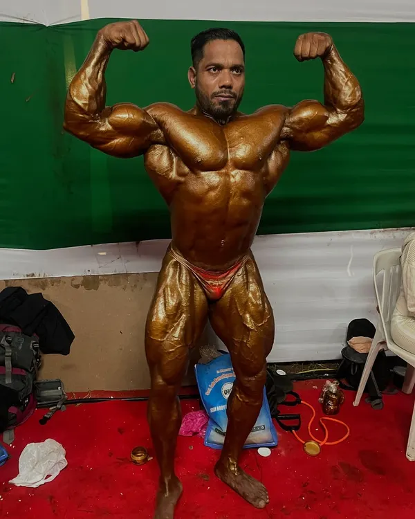 Backstage at the Mr. India competition, hitting a front double bicep pose. This is the final look before stepping on stage, the result of months of preparation.
