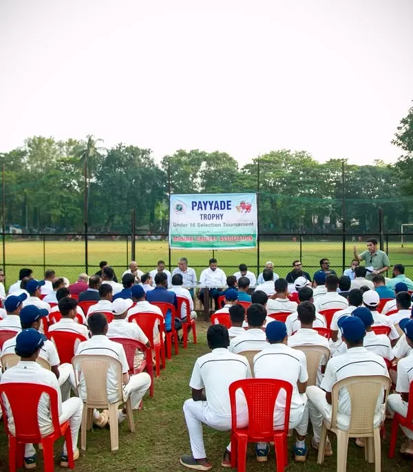 Young cricketers in their whites listen attentively during the prize distribution ceremony of the U-16 Payyade Trophy. This event marks a significant milestone for these budding Mumbai cricket stars.